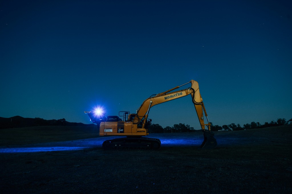 Komatsu excavator with work lights on at night