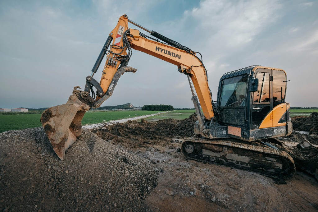 Yellow excavator on a gravel yard at a rental site